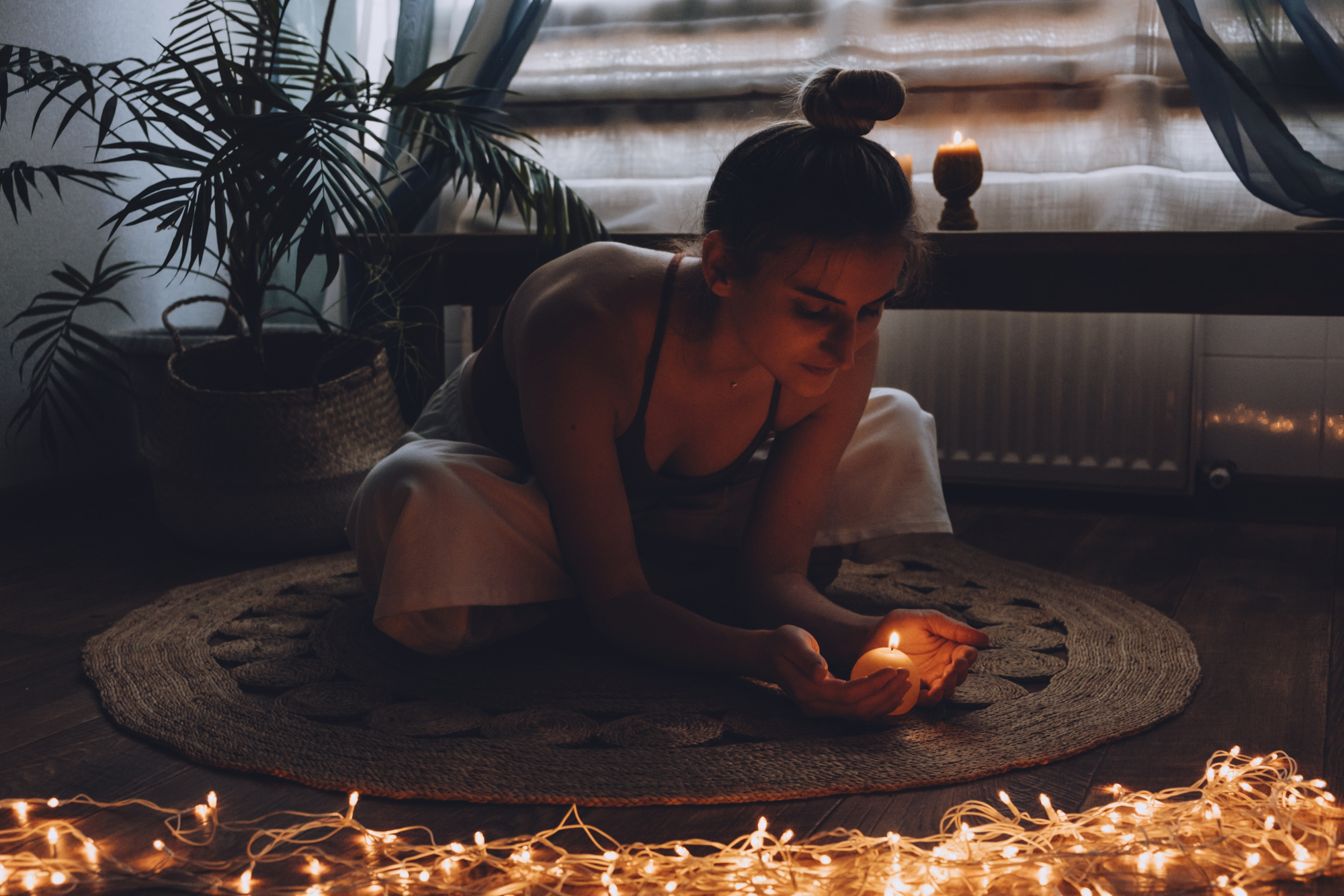 Woman Meditating with Candles and Lights