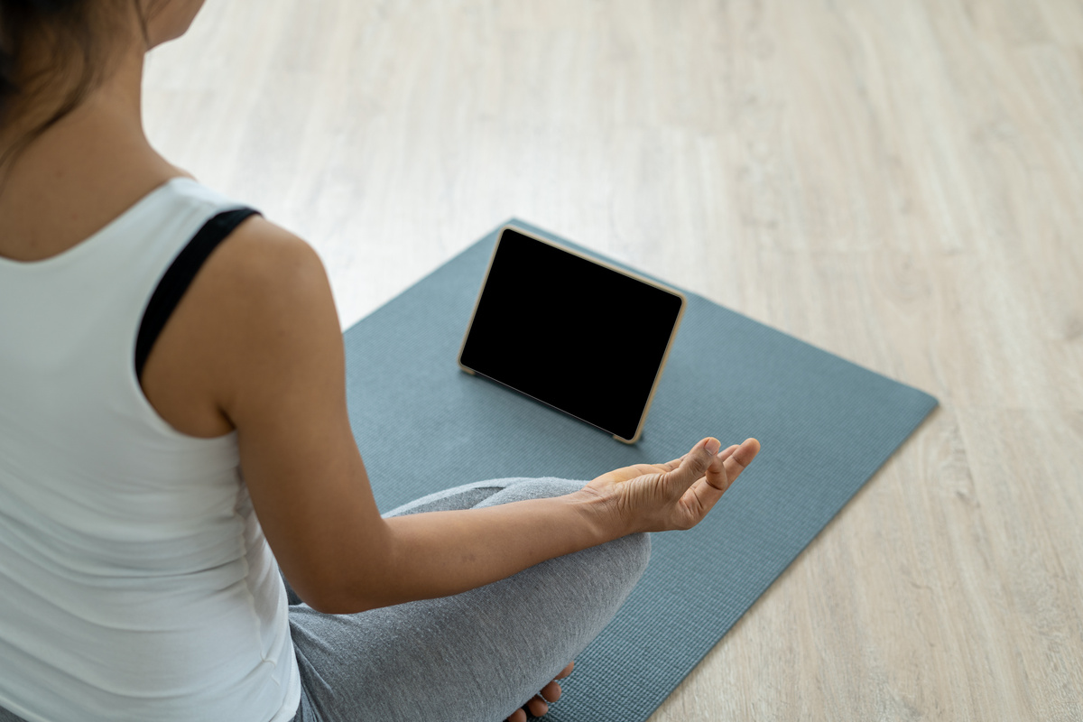 Woman Doing Meditation with Guide on Tablet